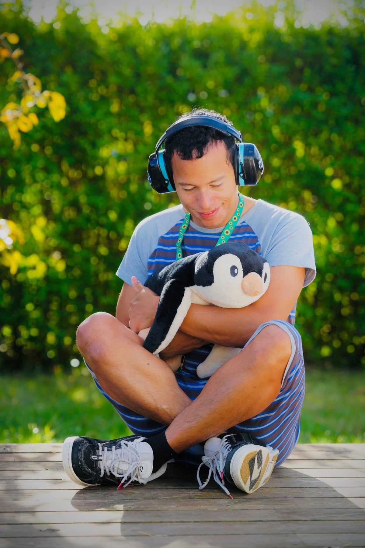 Martin Moxness hugging the weighted penguin with ear defenders on