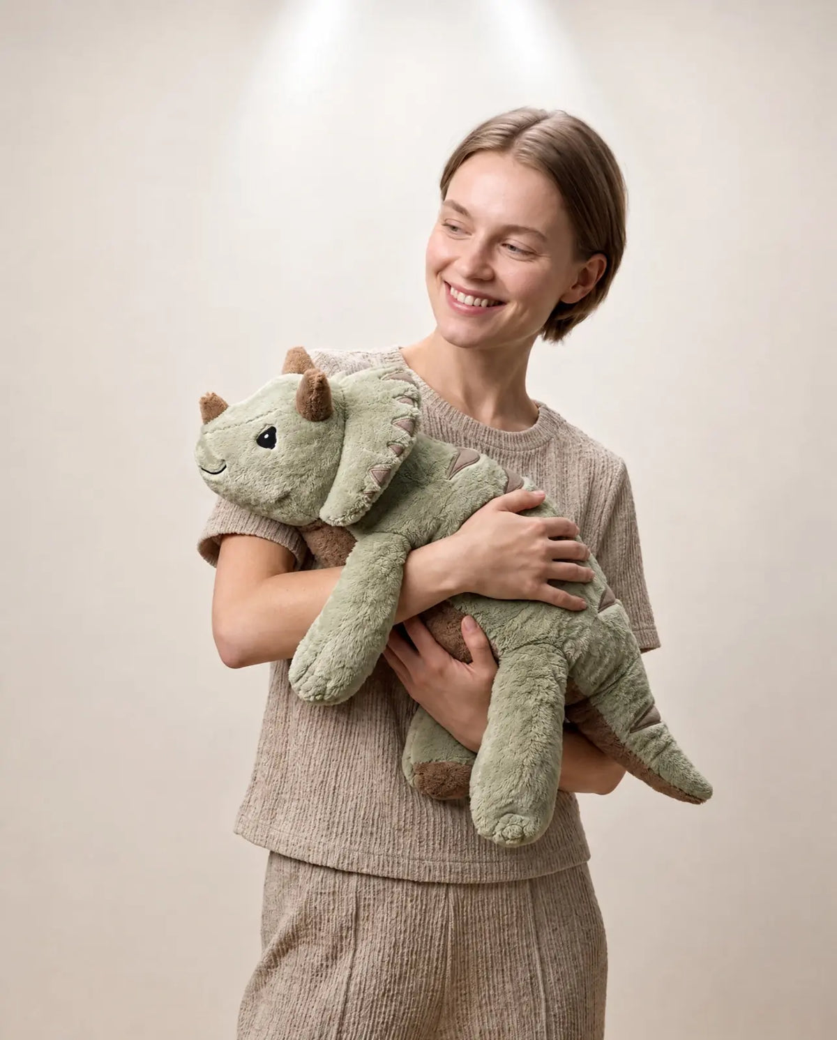 Woman holding the weighted Dinosaur in Matcha, 2.3 kg, in her arms