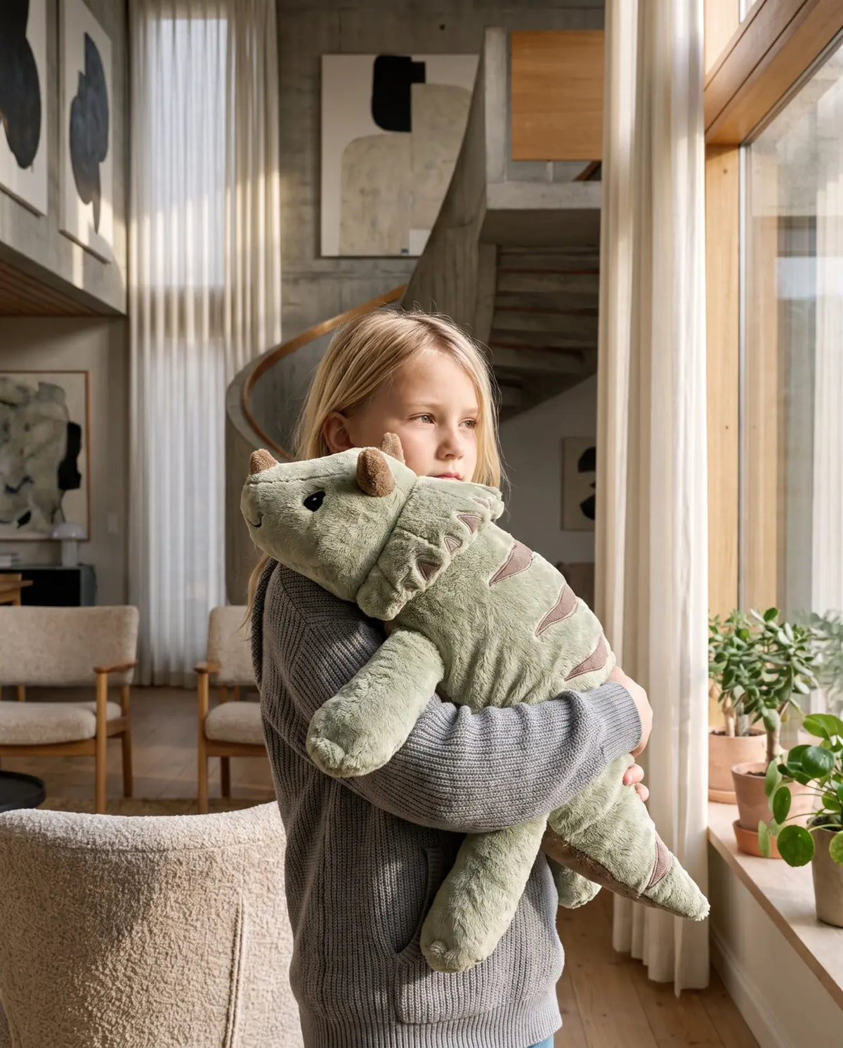Girl hugging the weighted Dinosaur in Matcha, 2.3 kg, at home