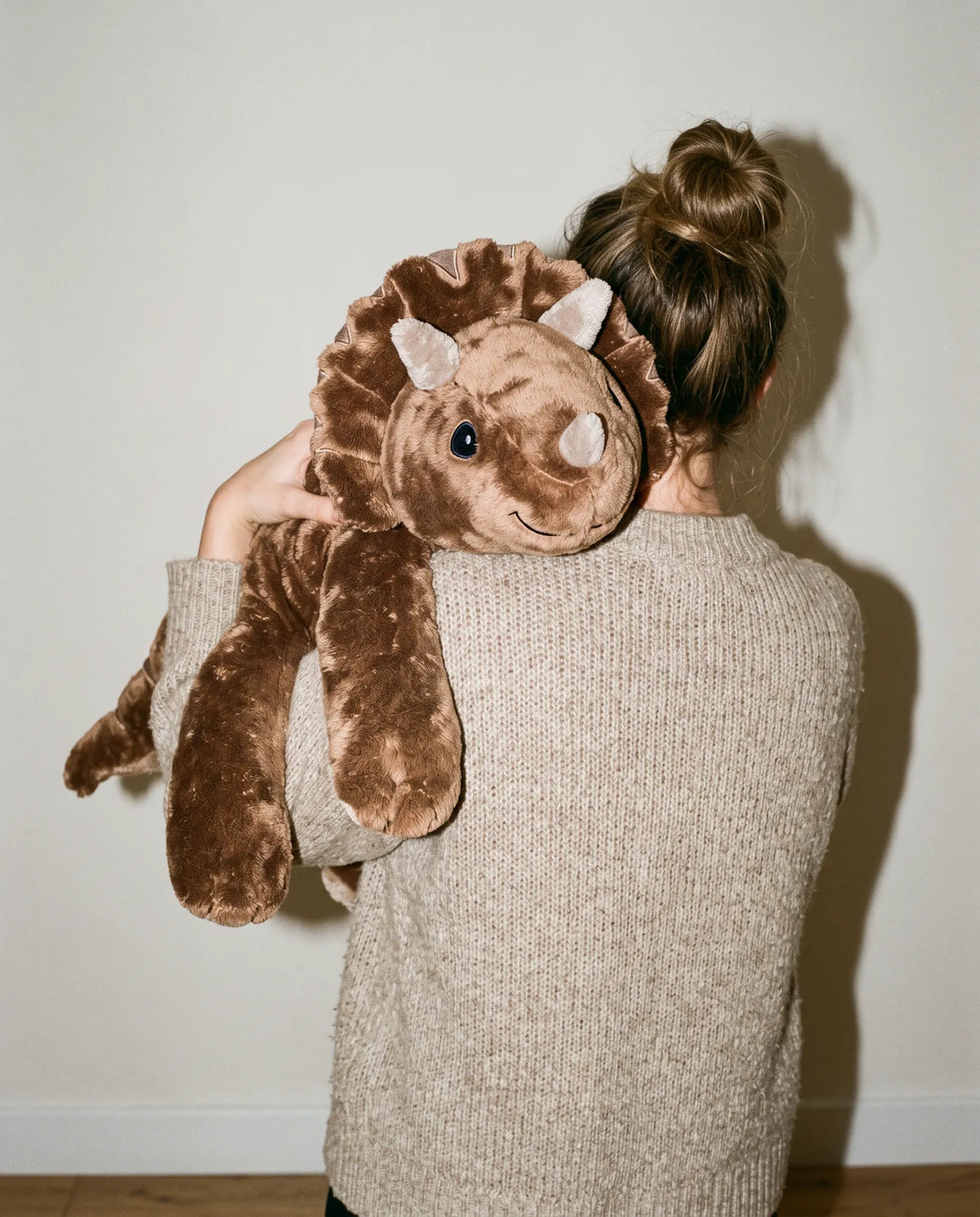 Woman seen from behind with the weighted Dinosaur in Coffee over her shoulder #Colour_Coffee