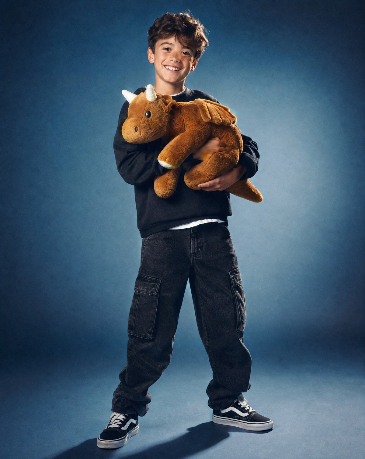 Boy holding the Brease Weighted Dragon 5 lb calming plush, size comparison against a child
