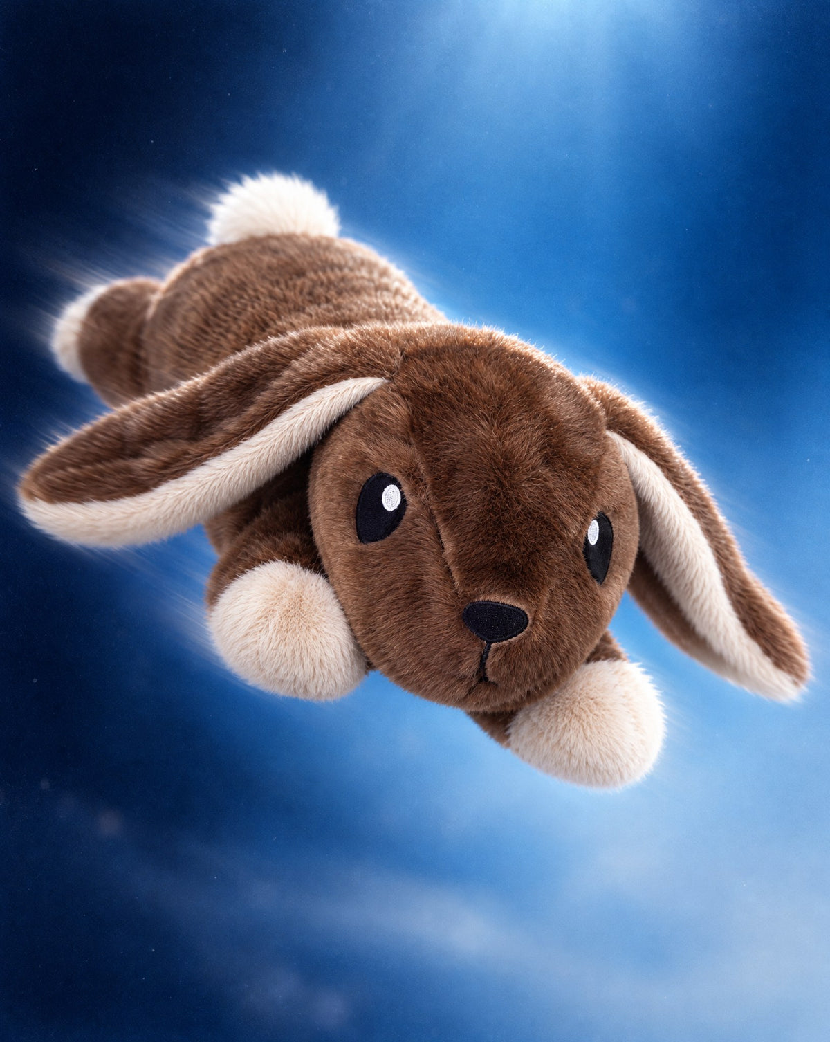 Brease Weighted Rabbit 5 lb floating playfully against a deep blue sky with its long lop ears trailing behind