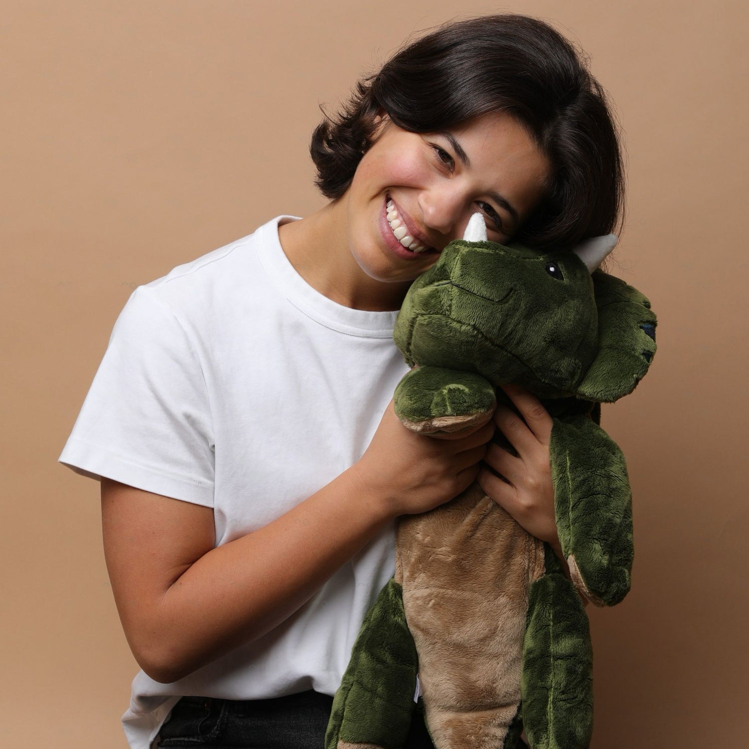 woman holding a weighted dinosaur plush from brease