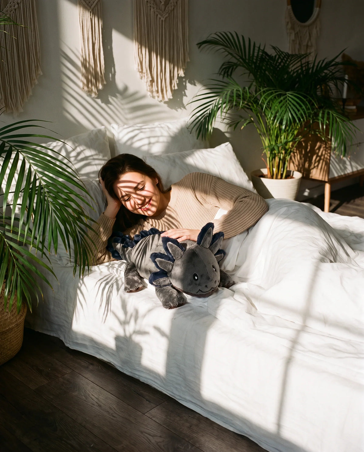 Young woman lying in bed with the weighted Axolotl in Blue Flame, 2.3 kg #Colour_Blue Flame