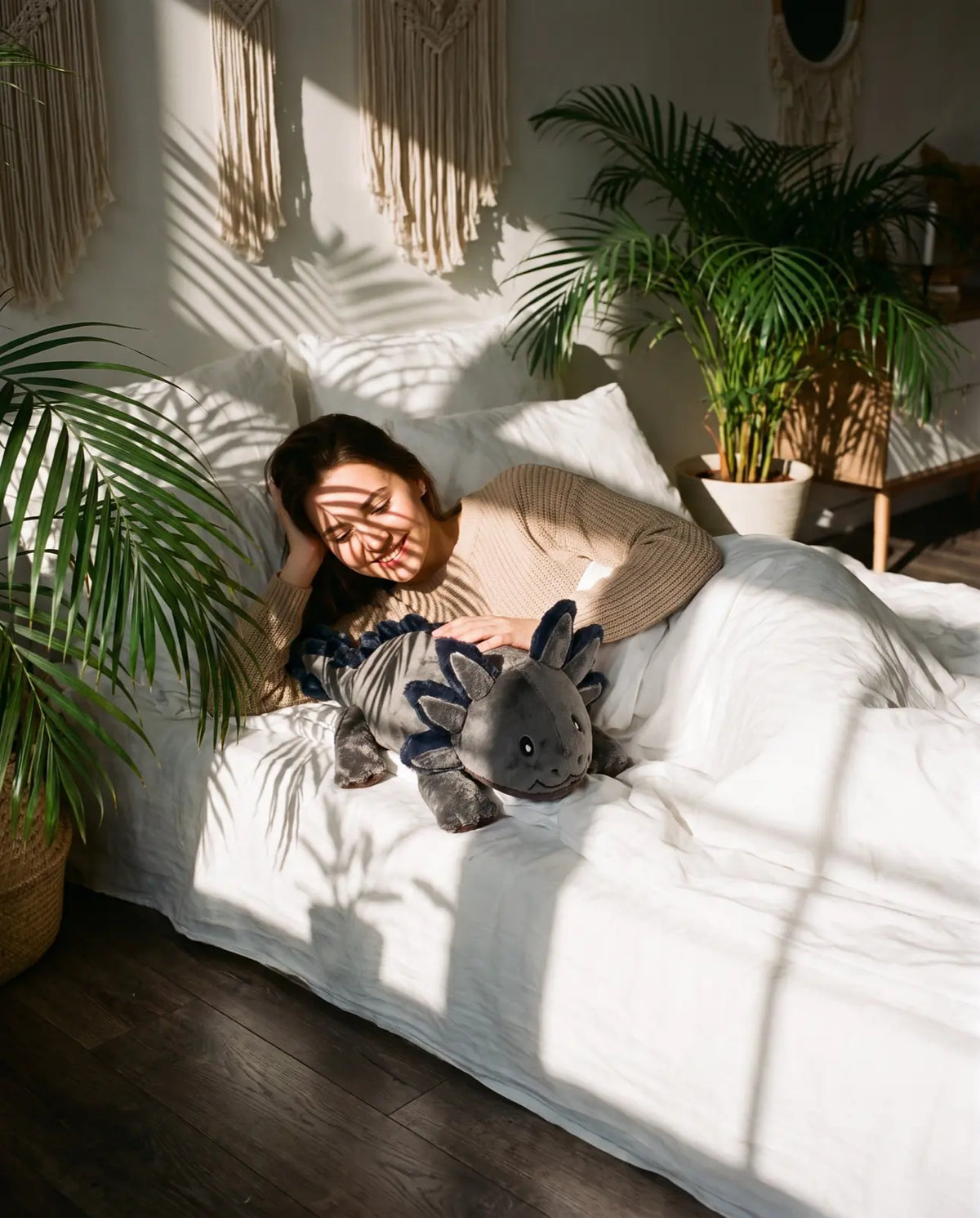 Young woman lying in bed with the weighted Axolotl in Blue Flame, 2.3 kg