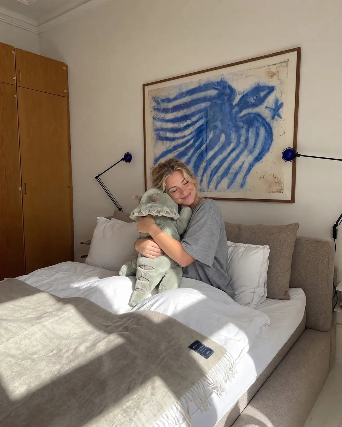 Woman in bed hugging the weighted Dinosaur in Matcha, 2.3 kg