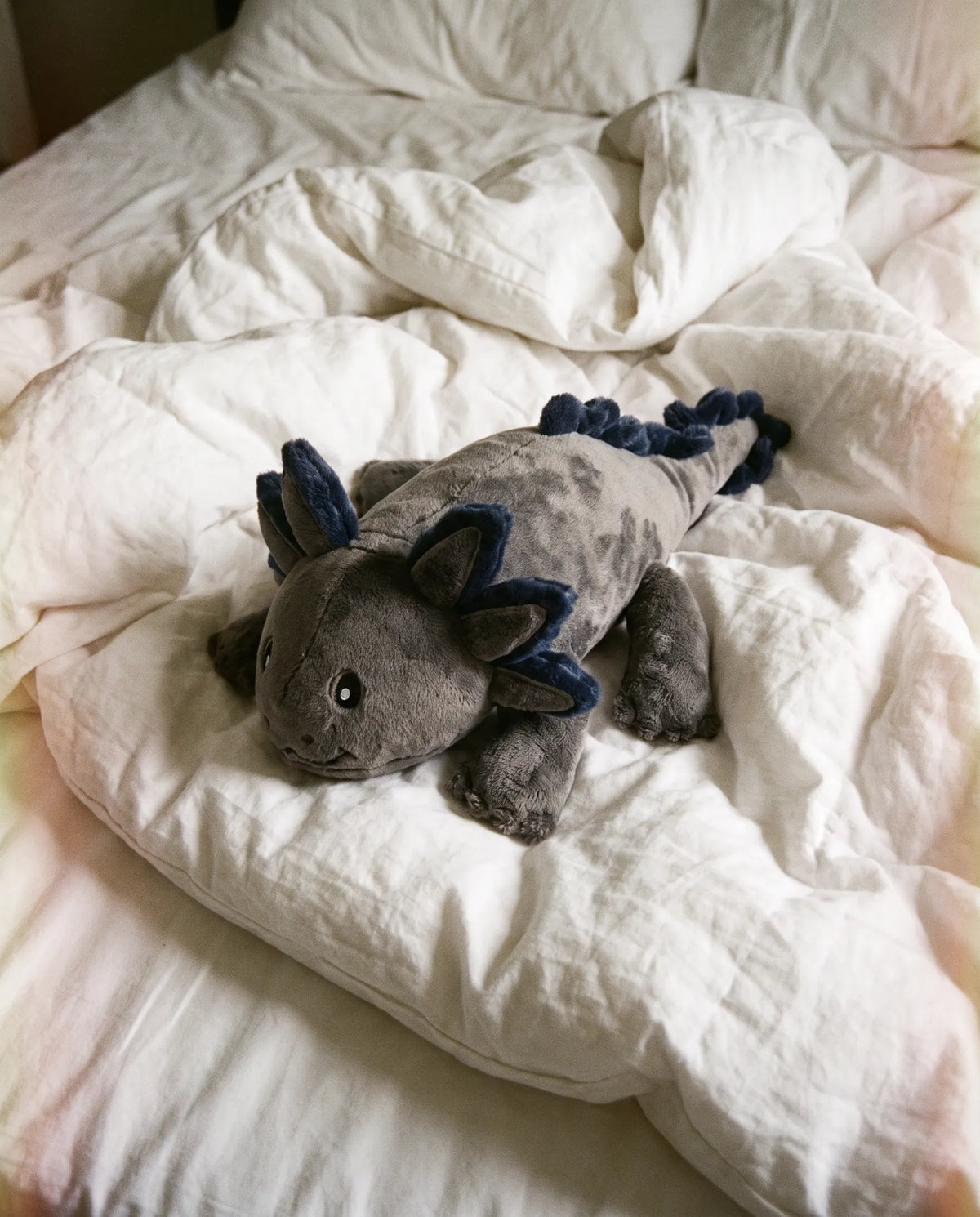 Weighted Axolotl in Blue Flame, 2.3 kg, resting on a white duvet