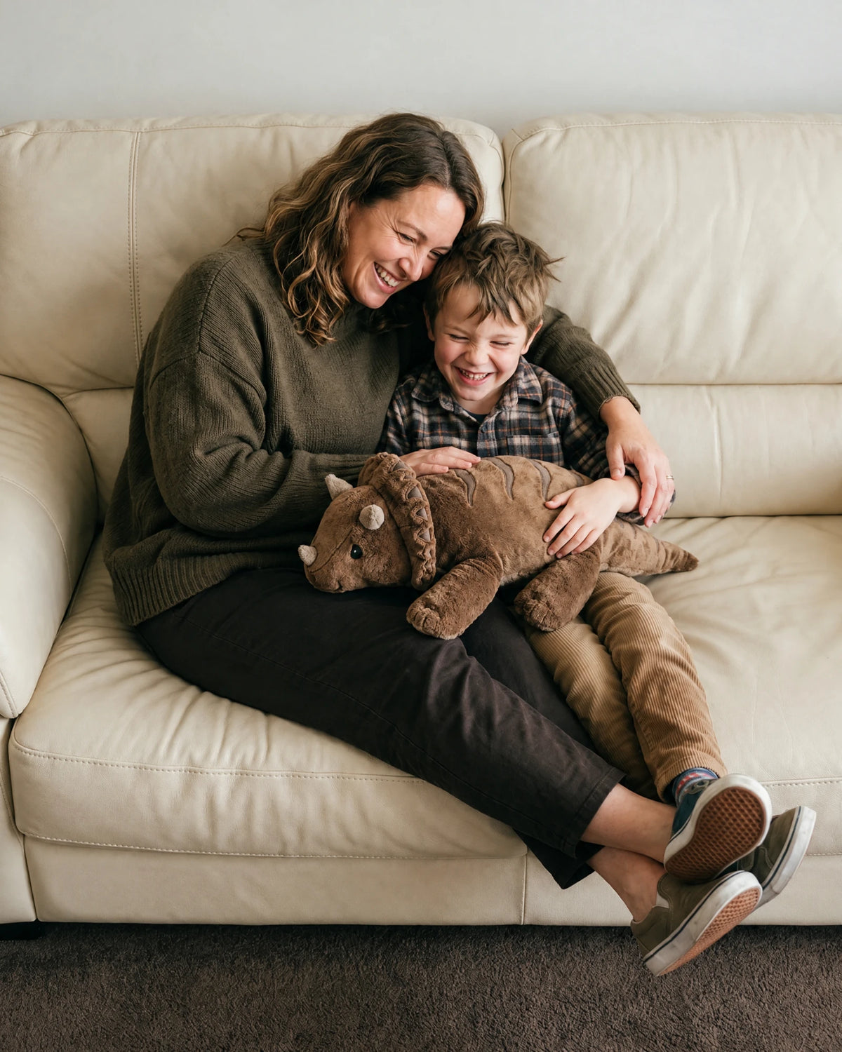 Mother and son laughing on the sofa with the weighted Dinosaur in Coffee #Colour_Coffee