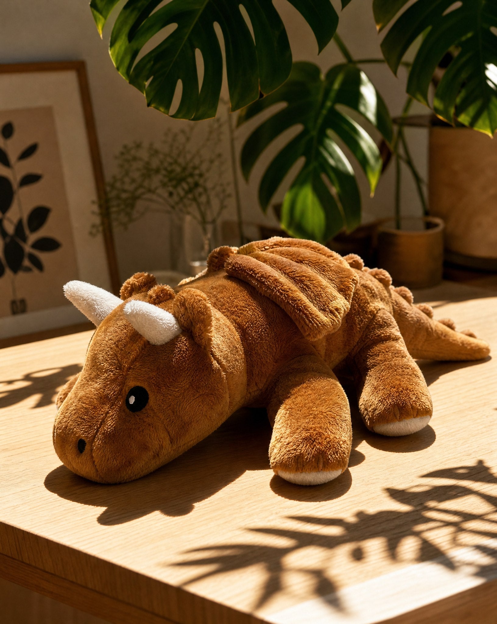Brease Weighted Dragon 5 lb resting on an oak table in sunlight, showing the spine spikes and folded wings